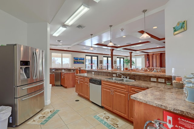 kitchen featuring kitchen peninsula, appliances with stainless steel finishes, sink, light tile patterned floors, and pendant lighting