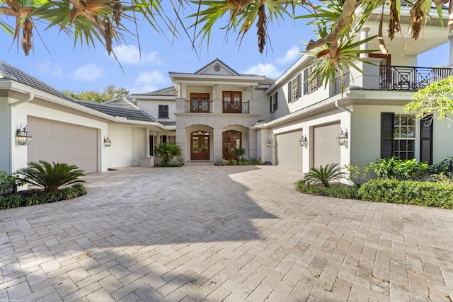 view of front of home with a balcony, french doors, and a garage