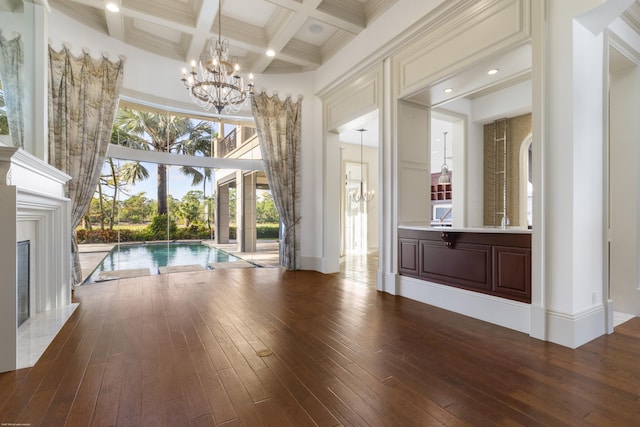 interior space featuring coffered ceiling, beam ceiling, an inviting chandelier, a premium fireplace, and hardwood / wood-style floors