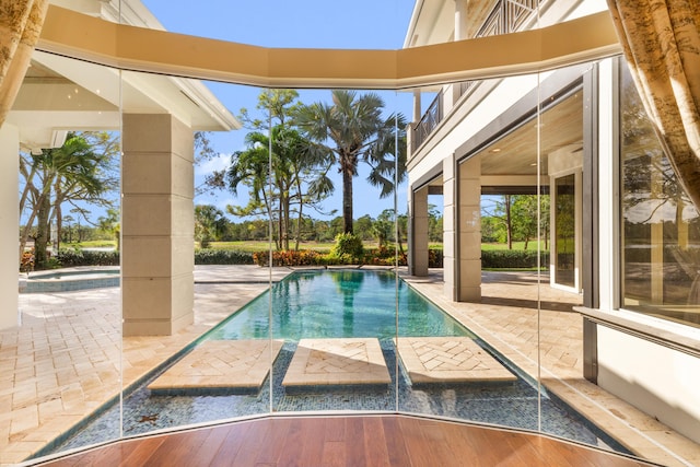 view of pool featuring an in ground hot tub, pool water feature, and a patio