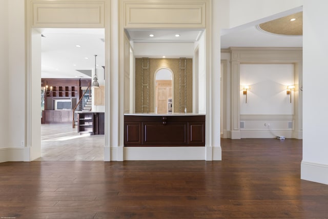 bar with an inviting chandelier, wood-type flooring, and cream cabinets