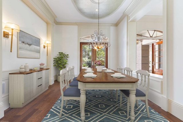 dining area with a chandelier, french doors, a tray ceiling, and dark wood-type flooring