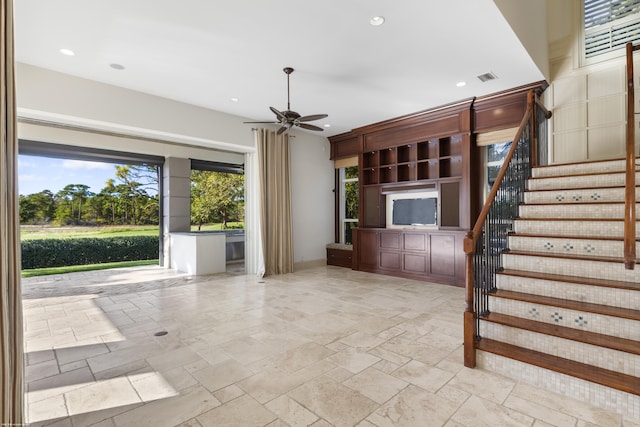 unfurnished living room with ceiling fan