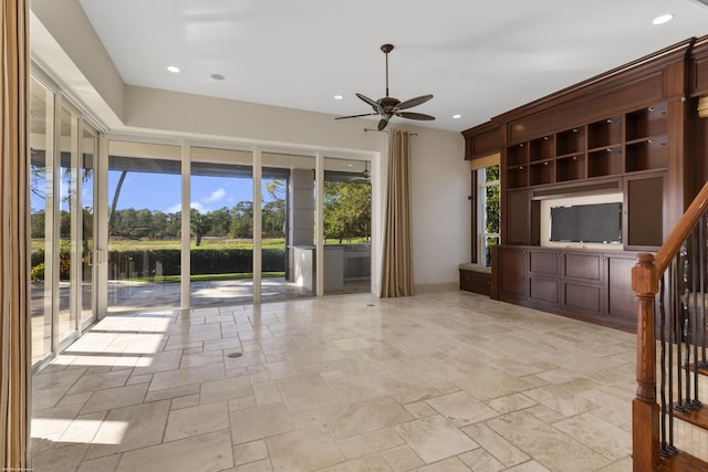 unfurnished living room with a water view and ceiling fan