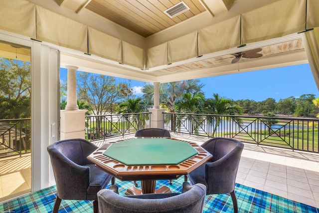 view of patio featuring ceiling fan, a water view, and a balcony