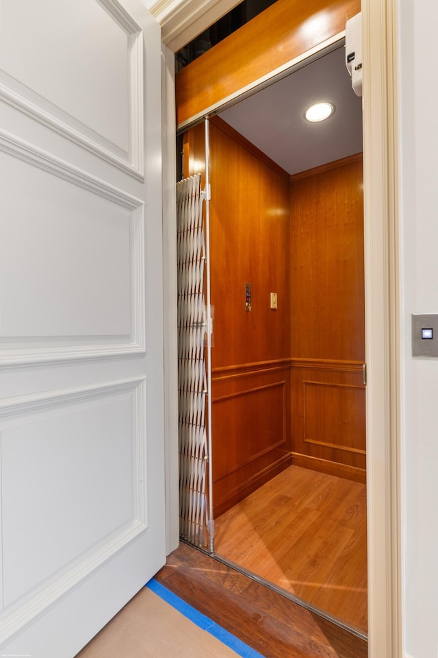 room details with hardwood / wood-style floors and elevator