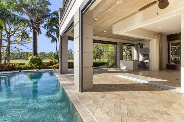 view of swimming pool featuring area for grilling, ceiling fan, and a patio area