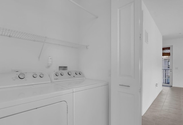 laundry room featuring light tile patterned floors and washing machine and clothes dryer