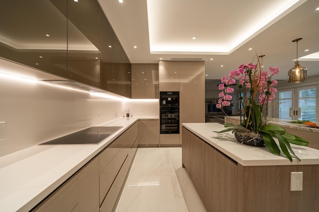 kitchen with gray cabinetry, decorative light fixtures, a raised ceiling, and black appliances