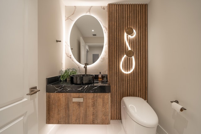 bathroom with tile patterned flooring, vanity, and toilet