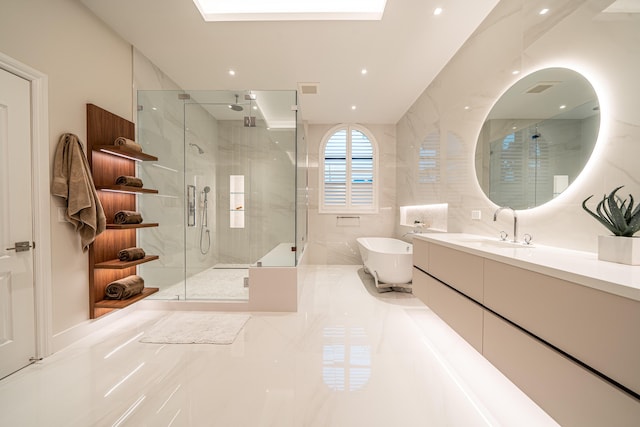 bathroom with independent shower and bath, vanity, tile walls, and a skylight