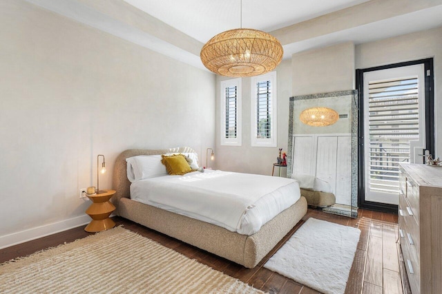 bedroom featuring multiple windows and dark wood-type flooring