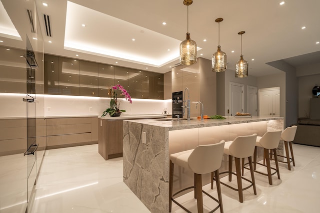 bar with light stone counters, decorative light fixtures, and a raised ceiling