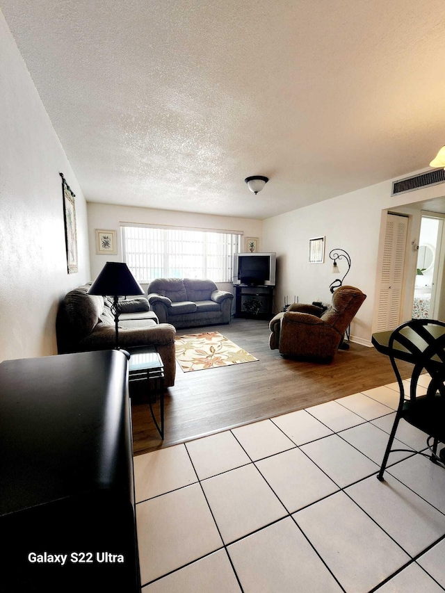 living room featuring light hardwood / wood-style floors and a textured ceiling