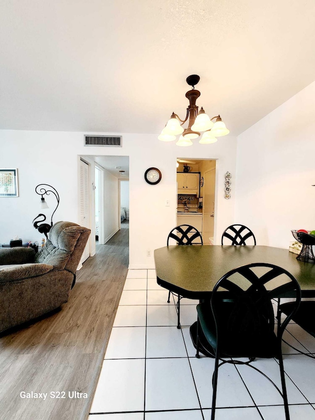 dining space featuring light wood-type flooring and a chandelier