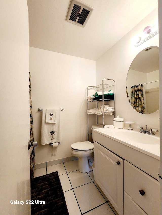 bathroom with tile patterned flooring, vanity, and toilet