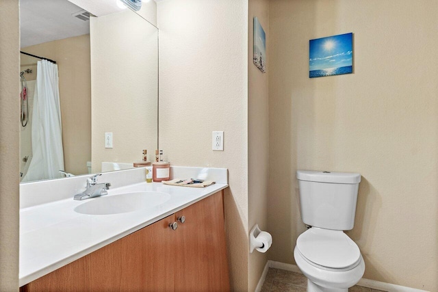 bathroom with tile patterned flooring, vanity, and toilet