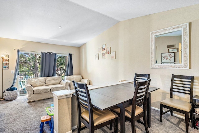 dining space featuring carpet and vaulted ceiling