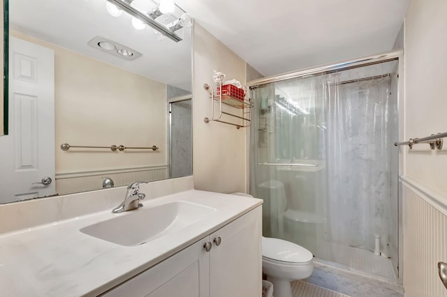 bathroom with tile patterned floors, vanity, toilet, and a shower with door