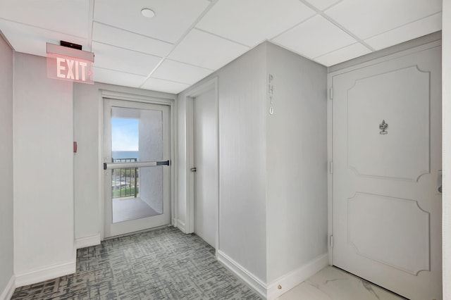 hall featuring a paneled ceiling