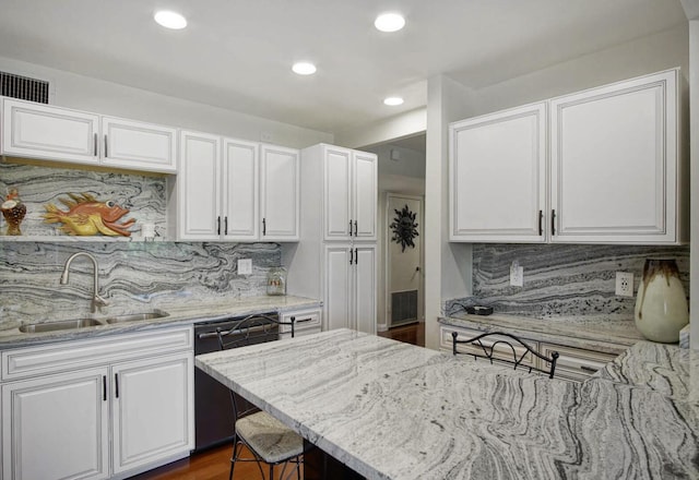 kitchen featuring dishwasher, decorative backsplash, white cabinetry, and sink