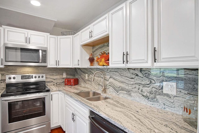 kitchen featuring light stone countertops, sink, stainless steel appliances, backsplash, and white cabinets