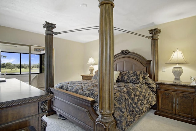 carpeted bedroom featuring access to outside and decorative columns