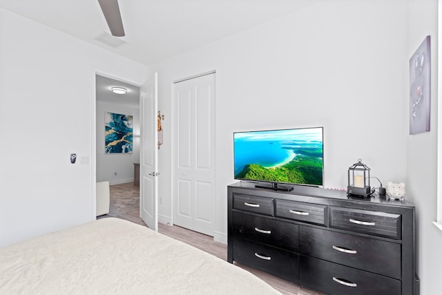 bedroom featuring ceiling fan, a closet, and light hardwood / wood-style floors