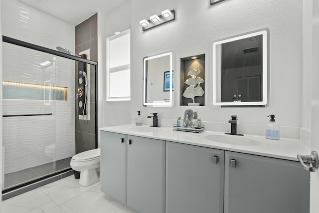 bathroom featuring vanity, a shower with shower door, and toilet