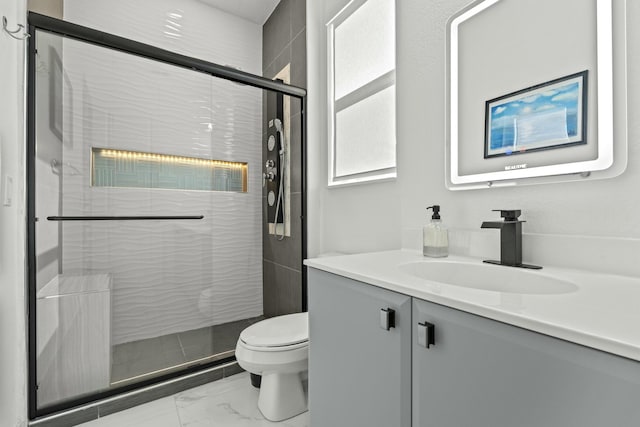 bathroom featuring vanity, toilet, and an enclosed shower