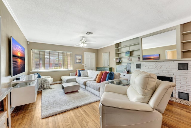 living room featuring a fireplace, a textured ceiling, and light hardwood / wood-style flooring