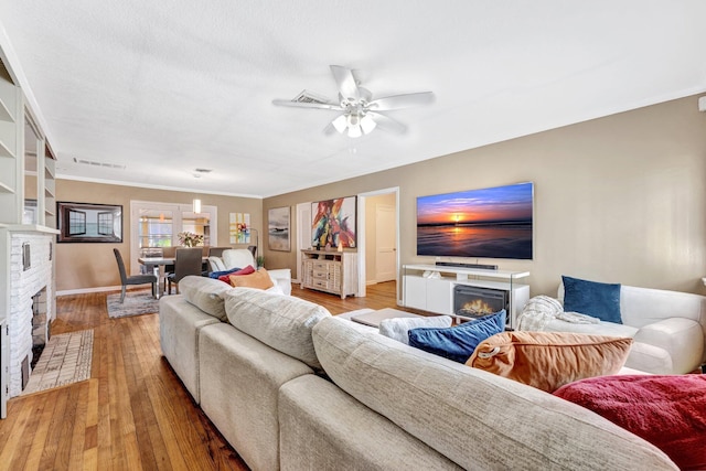 living room with ceiling fan, wood-type flooring, and crown molding