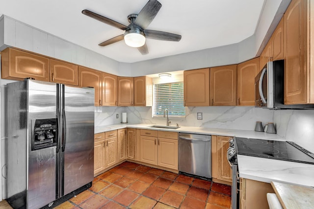 kitchen featuring appliances with stainless steel finishes, tasteful backsplash, ceiling fan, sink, and light brown cabinets