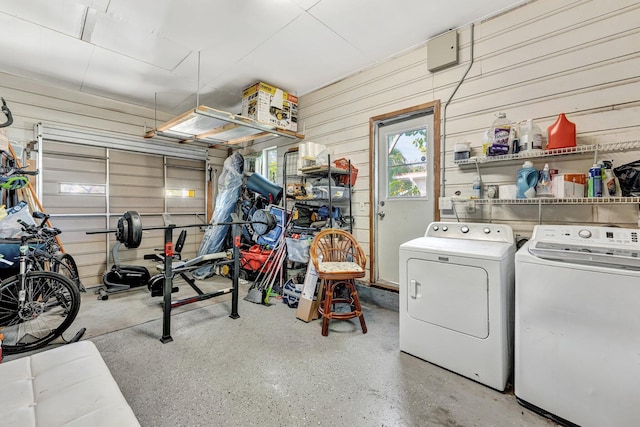 garage featuring wooden walls and washing machine and clothes dryer