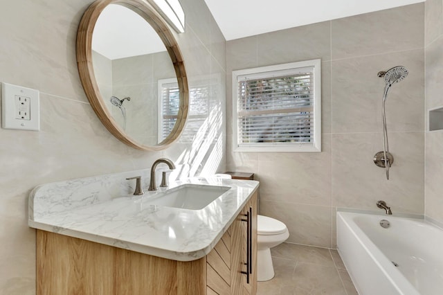 full bathroom with vanity, shower / washtub combination, tile patterned flooring, toilet, and tile walls