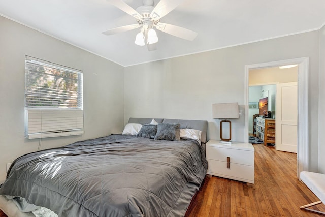 bedroom with ceiling fan, wood-type flooring, and ornamental molding