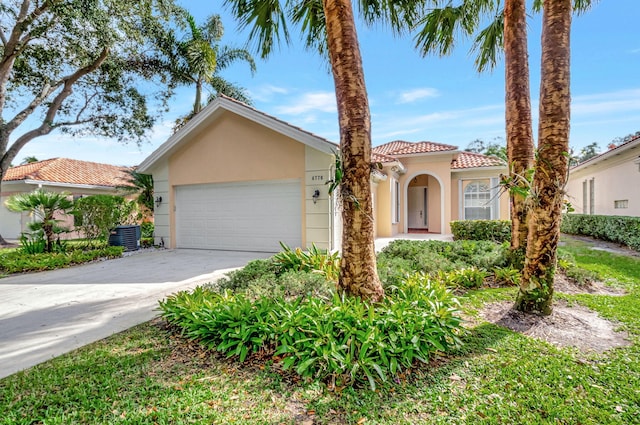 view of front of home with a garage and central AC