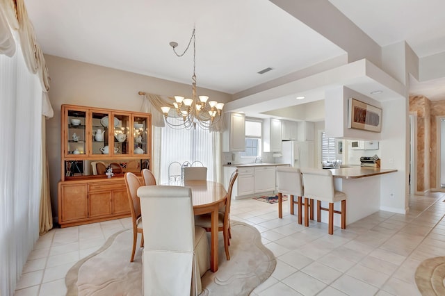 dining space with an inviting chandelier and light tile patterned flooring