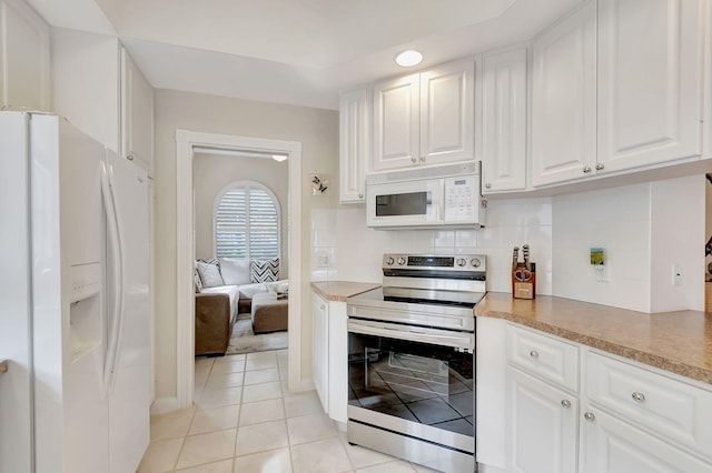 kitchen featuring decorative backsplash, white cabinetry, light tile patterned floors, and white appliances