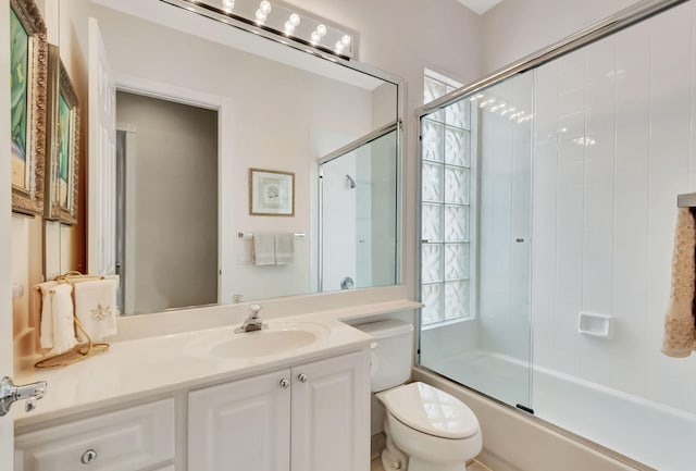 full bathroom with vanity, toilet, and bath / shower combo with glass door