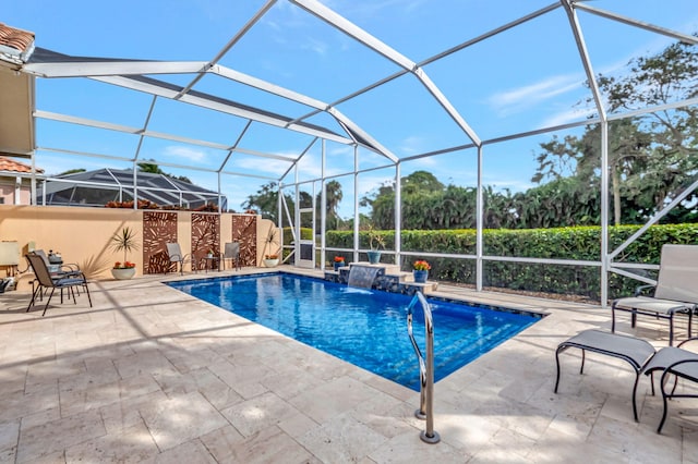 view of swimming pool with glass enclosure, pool water feature, and a patio area