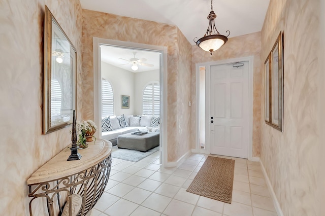 foyer entrance featuring light tile patterned floors and ceiling fan