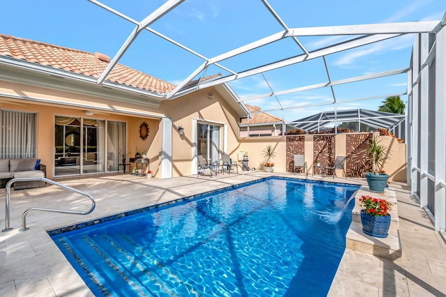 view of swimming pool with glass enclosure and a patio area