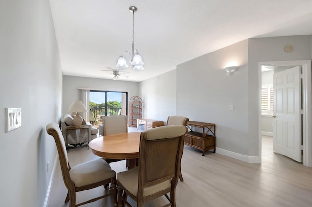 dining space with ceiling fan with notable chandelier and light hardwood / wood-style floors