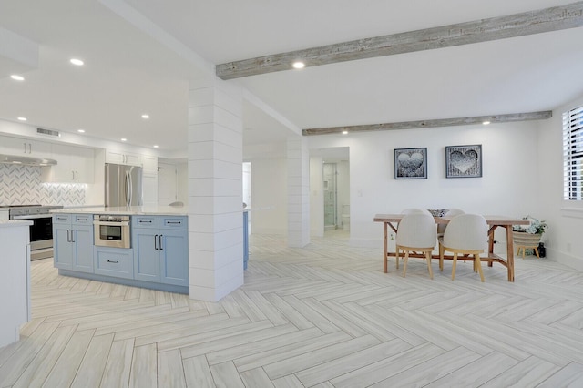 kitchen featuring white cabinetry, tasteful backsplash, light parquet flooring, and appliances with stainless steel finishes