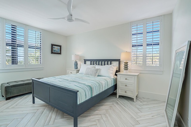 bedroom with light parquet flooring, ceiling fan, and multiple windows