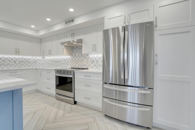 kitchen with decorative backsplash, white cabinets, light parquet flooring, and appliances with stainless steel finishes