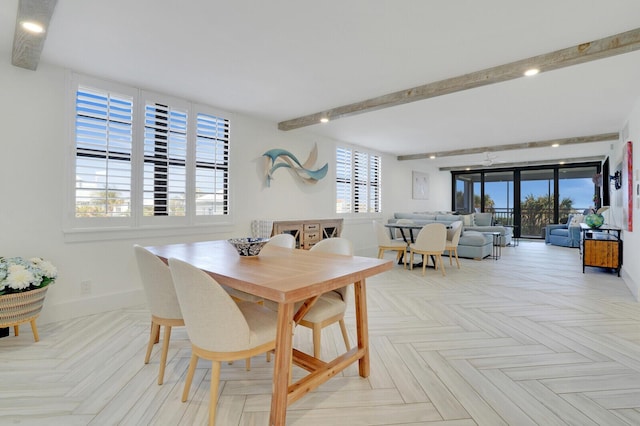 dining area featuring a wealth of natural light, beamed ceiling, and light parquet flooring