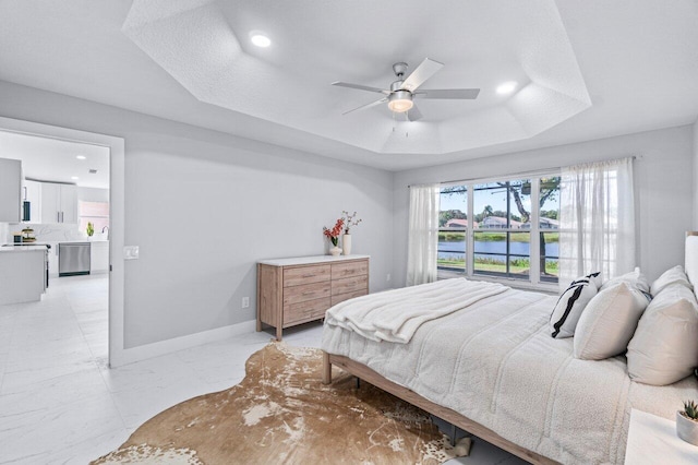 bedroom with a raised ceiling and ceiling fan