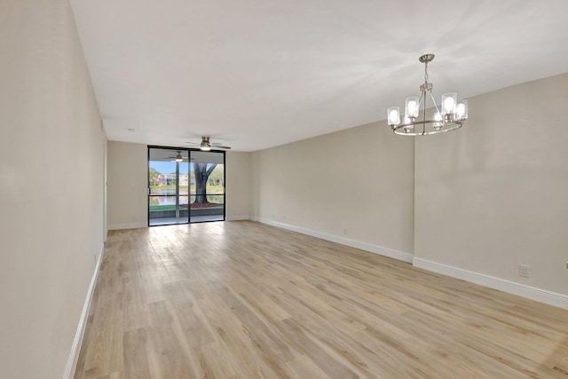 spare room with ceiling fan with notable chandelier and light hardwood / wood-style flooring